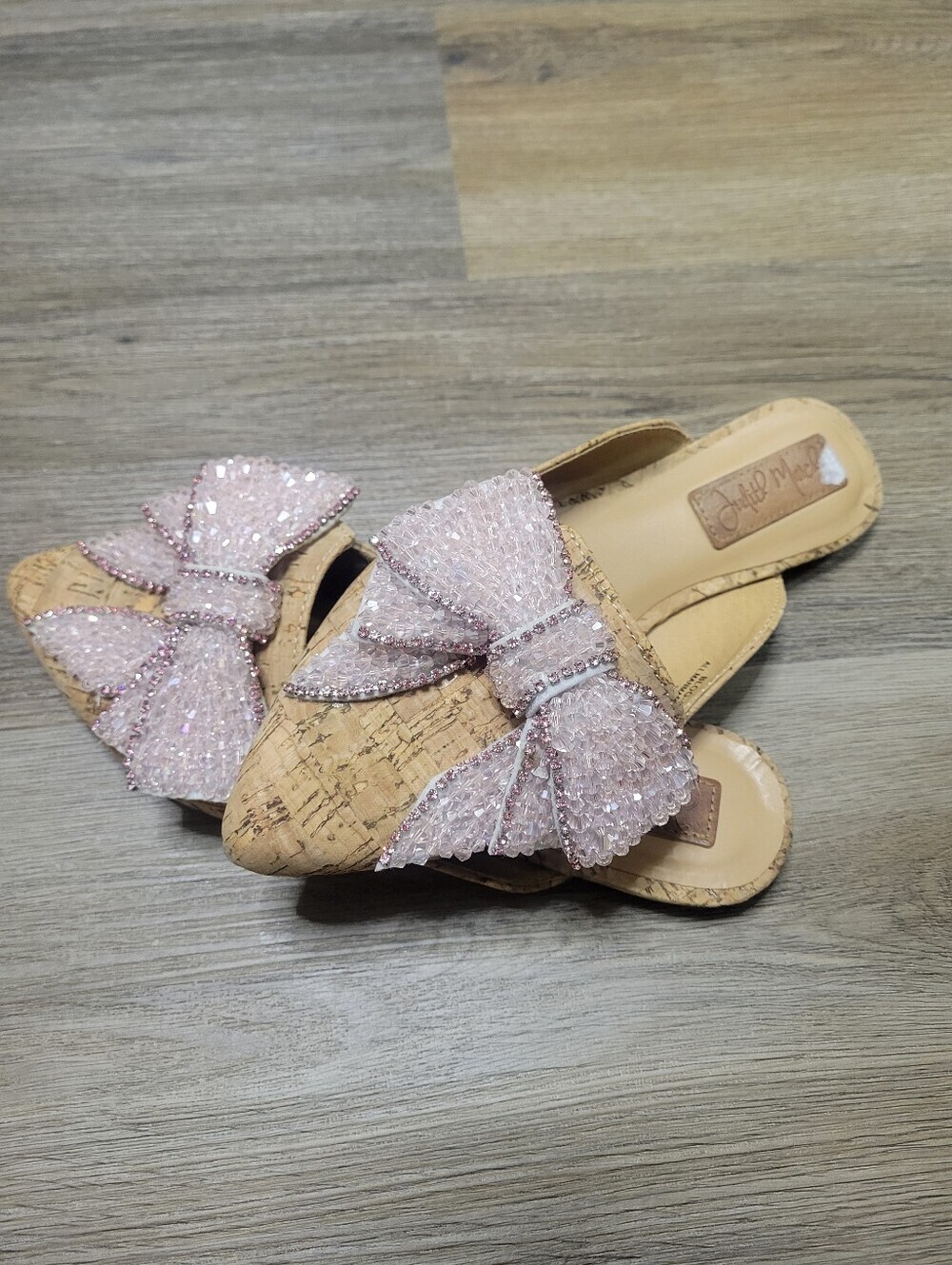 Judith March cork slip-on mules feature a large, embellished pink bow detail